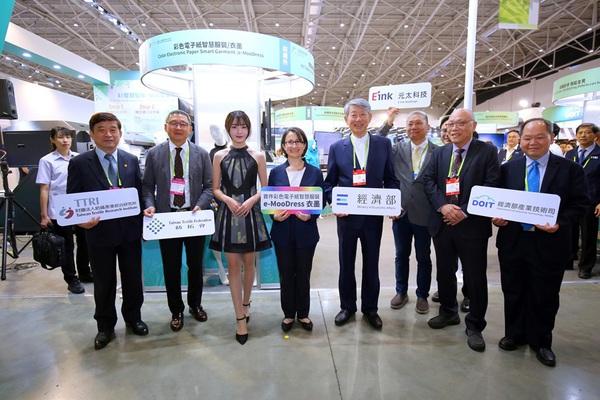圖三 : 圖左起為紡織綜合所所長李貴琪、紡拓會董事長郭紹儀、穿著彩色電子紙智慧服飾e-MooDress的模特兒、副總統蕭美琴、經濟部部長郭智輝、元太科技協理陳俊賢、產紡協會理事長黃鯤雄、經濟部產業技術司副司長周崇斌。(source:紡織綜合所)